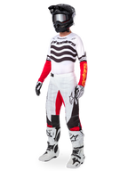 Alpinestars Limited Edition Techstar Deep Gear Set, vollständige Motocross-Rennausrüstung, weißes Trikot mit schwarzen Wellenmustern und roten Ärmeln, weiße Hose mit roten und schwarzen Akzenten, schwarzer Helm mit silberner Brille, weiß-schwarze Handschuhe, weiße Stiefel, abgestimmtes MX-Rennoutfit
