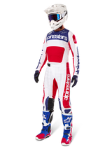 Motocross-Fahrer in kompletter Rennausrüstung, mit dem Alpinestars Limited Edition Techstar Fortitude Jersey in Hellrot, Weiß und Blau. Passende Motocross-Hose, weißer Helm mit blauer Brille und blau-rote Stiefel bieten einen koordinierten Look für den Offroad-Wettbewerb.
