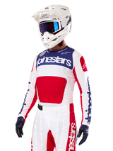 Motocross-Fahrer im Alpinestars Limited Edition Techstar Fortitude Jersey, Bright Red White Blue, mit weißem Helm, blauer Brille und passender Hose, Hochleistungs-Rennbekleidung für Offroad-Wettkämpfe