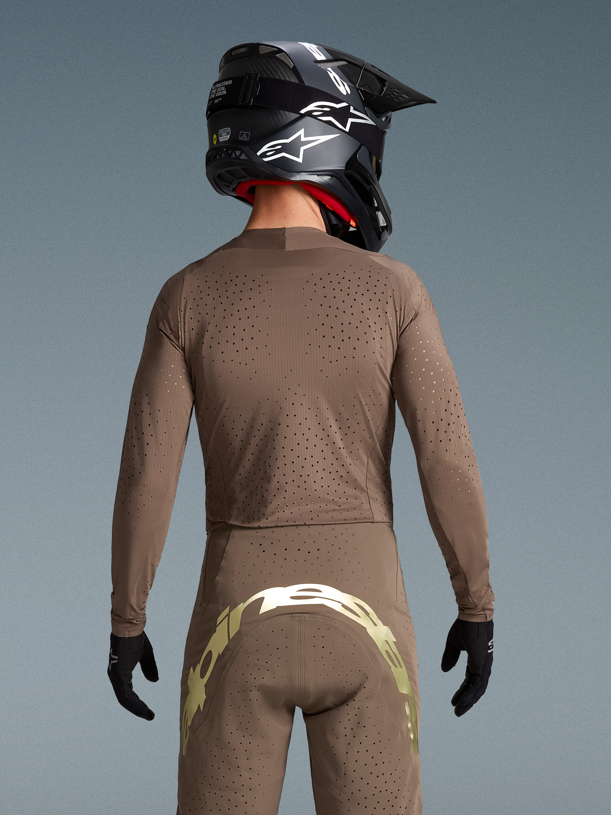 Alpinestars Supertech Air Gold Bekleidungsset, Rückansicht mit lasergeschnittener Belüftung und Metallic-Branding.