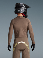 Alpinestars Limited Edition Supertech Air Gold Trikot und MX-Hose, Motocross-Ausrüstung, Herren, Braun und Gold, lasergeschnittene Belüftung, Rückansicht eines Fahrers mit Helm