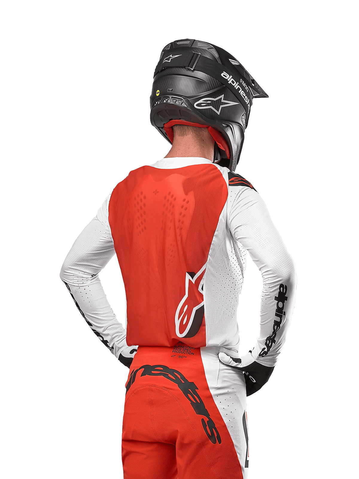 Motocross-Fahrer im 2024 Supertech Ward Jersey in White Hot Orange, Rückansicht mit orangefarbenem Rückenpanel und weißen Ärmeln mit schwarzem Alpinestars-Branding, kombiniert mit passender Hose und einem schwarzen Helm, professionelle Ausrüstung für den Offroad-Rennsport