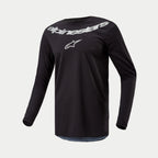 Alpinestars 2024 Fluid Graphite Jersey, Motocross-Trikot, Schwarz Silber, langärmliges Performance-Oberteil mit großem silbernem Alpinestars-Branding und Stern-Logo auf der Brust, leichtes feuchtigkeitsableitendes Poly-Gewebe für den Offroad-Einsatz