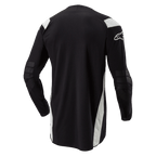 Alpinestars Techdura Jersey, Enduro-Motocross-Trikot, Schwarz mit weißen Akzenten, Rückansicht mit verlängertem Rückenteil, verstärkte Ellbogen und weißes Alpinestars-Logo auf dem Ärmel, strapazierfähige Offroad-Bekleidung