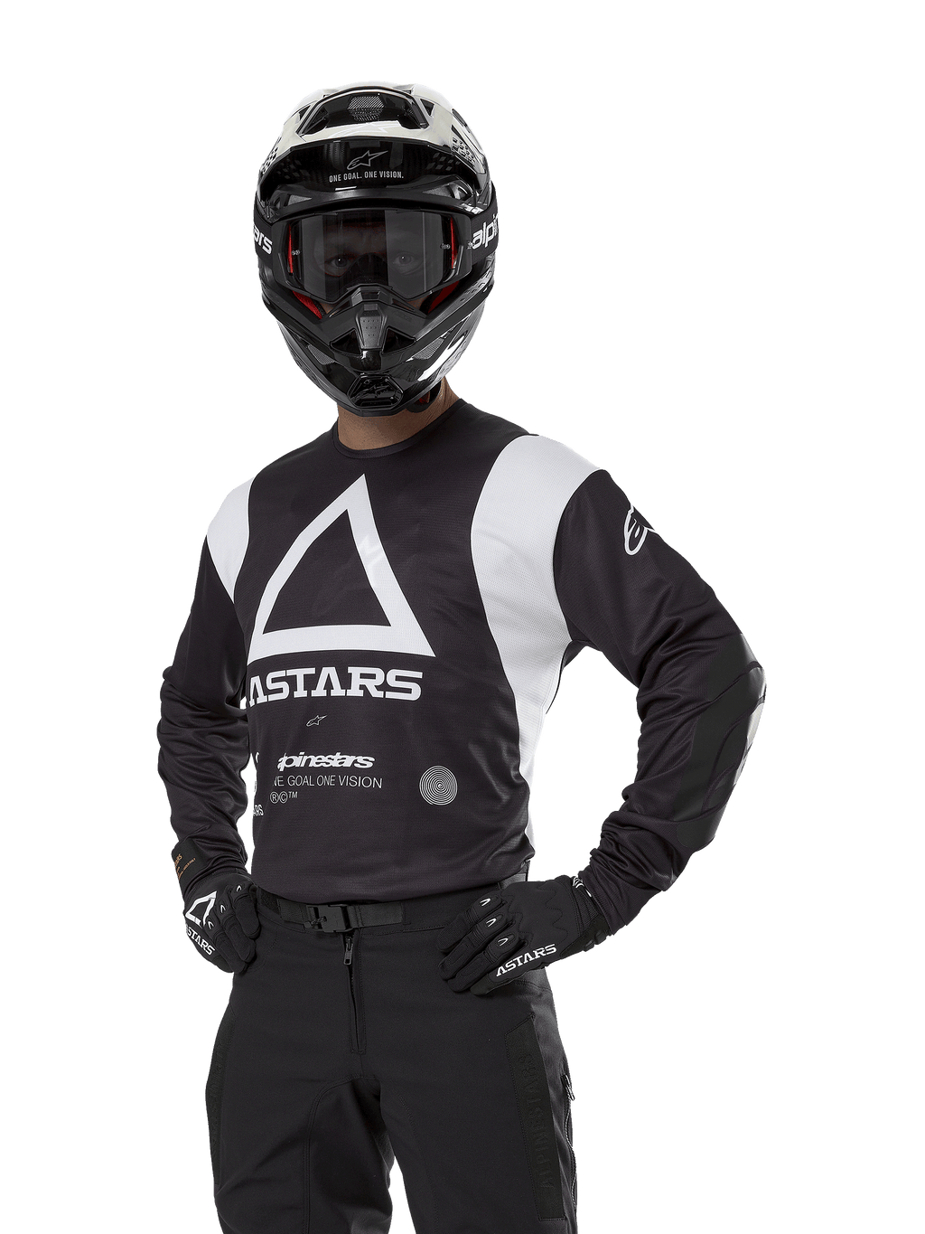 Alpinestars Techdura Jersey, Motocross-Trikot, Schwarz und Weiß, getragen mit passendem Helm und Handschuhen, Pose mit den Händen auf den Hüften vor weißem Hintergrund, mit großem Dreieck-A-Logo und ASTARS-Branding