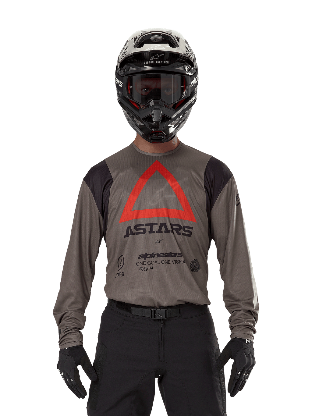Motocross-Fahrer im Alpinestars Techdura Jersey in Falcon Brown, mit einem markanten roten Dreieck und „ASTARS“-Branding auf der Brust, kombiniert mit schwarzer Hose, schwarzem Helm mit Brille und schwarzen Handschuhen, komplette Enduro-Rennausrüstung.