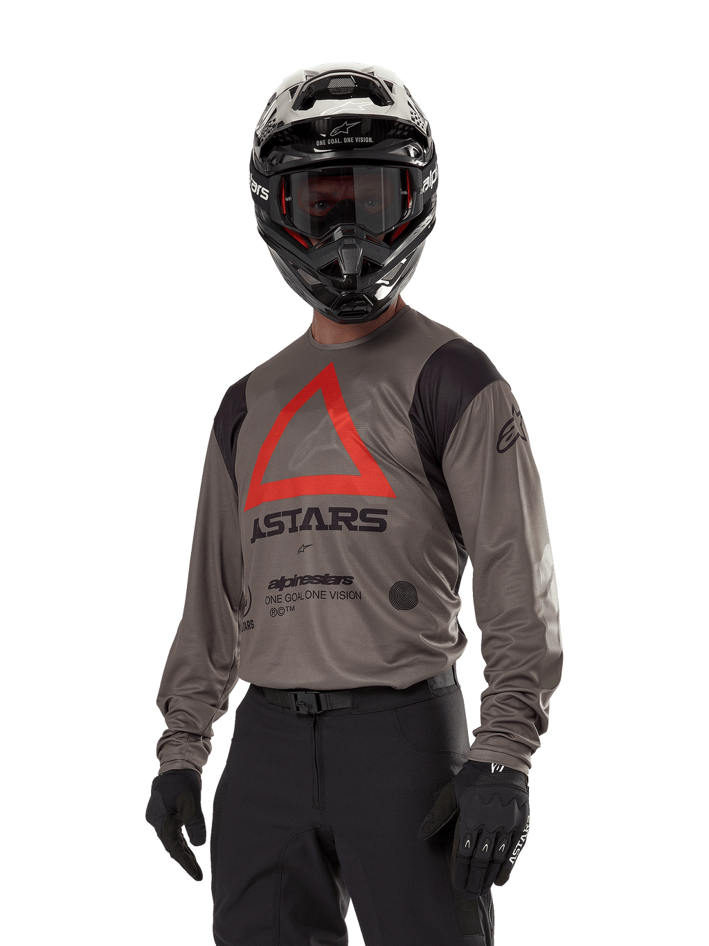 Alpinestars Techdura Jersey, Motocross-Offroad-Trikot, Falcon Brown mit rotem Dreieck und schwarzem Branding, getragen mit schwarzer Hose, schwarz-weißem Helm und schwarzen Handschuhen