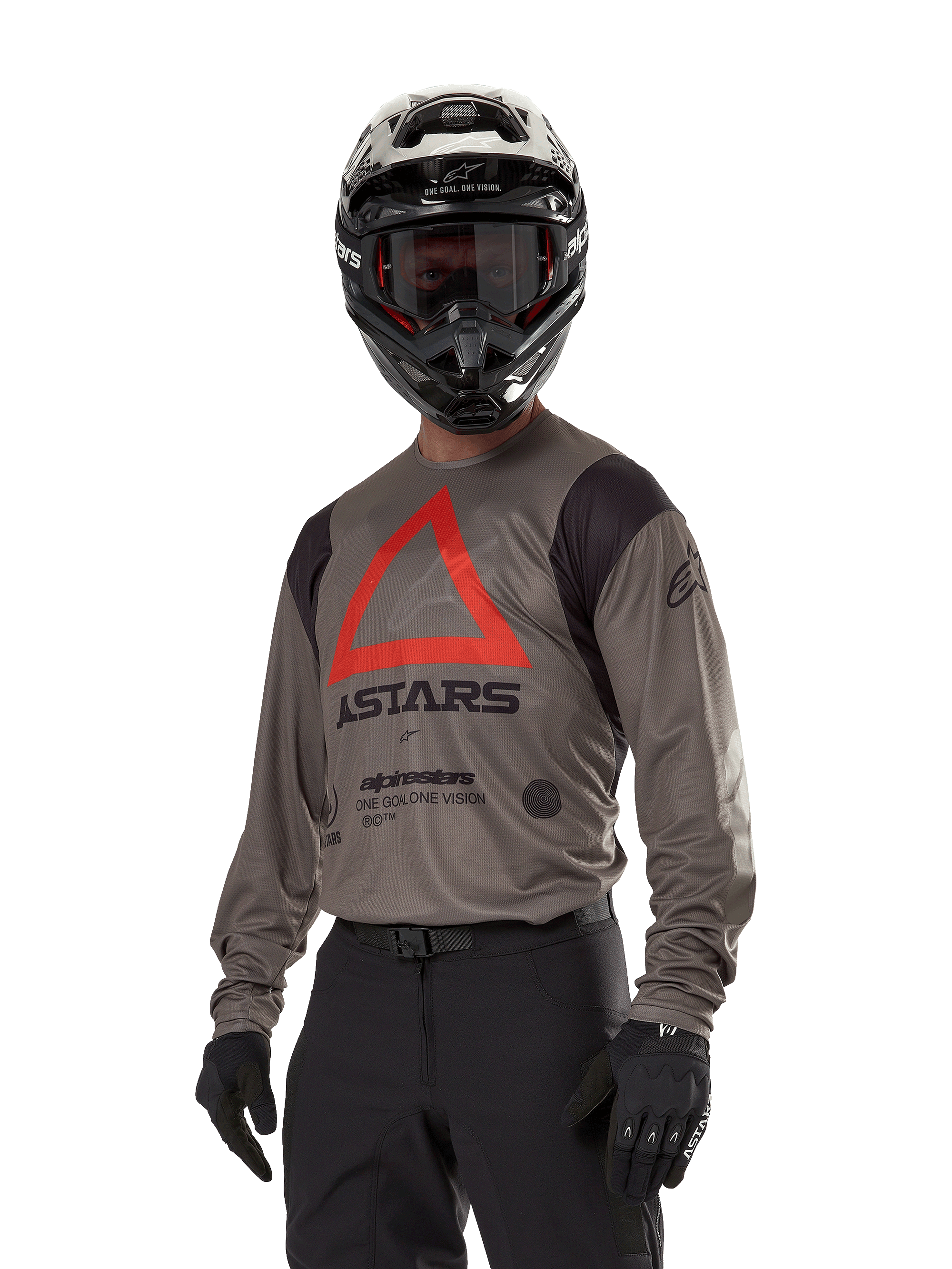 Alpinestars Techdura Jersey, Motocross-Offroad-Trikot, Falcon Brown mit rotem Dreieck und schwarzem Branding, getragen mit schwarzer Hose, schwarz-weißem Helm und schwarzen Handschuhen