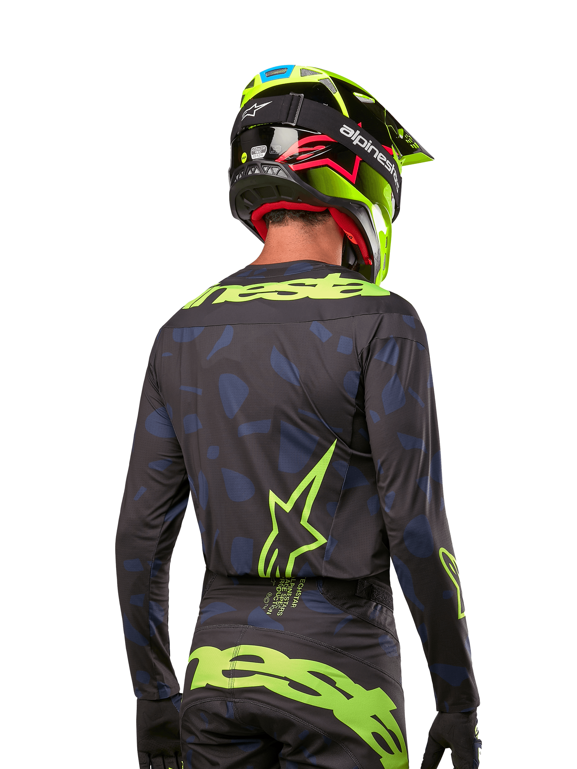 Rückansicht eines Motocross-Fahrers im Alpinestars 2024 Techstar Rantera Jersey in Schwarz Navy Gelb Fluo, mit auffälligem neongelbem Branding und Logos auf dem Rücken, kombiniert mit der passenden Motocross-Hose und einem neongelben Helm für einen kompletten Offroad-Racing-Look.