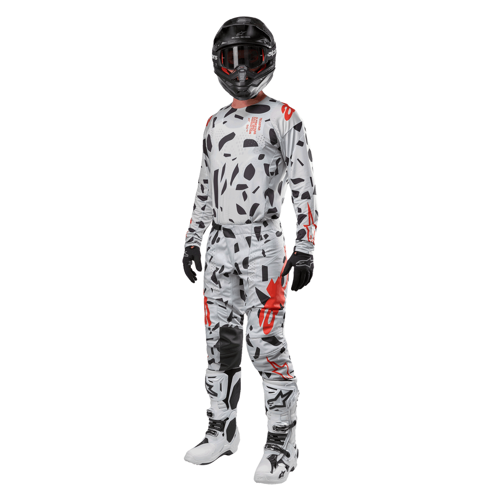 Motocross-Fahrer im Alpinestars 2024 Techstar Rantera Trikot in Haze Gray Camo, passende Hose mit roten und schwarzen Akzenten, schwarzer Helm und Brille, schwarze Handschuhe, weiße und schwarze Stiefel, komplette abgestimmte Motocross-Rennausrüstung für Offroad-Performance