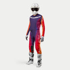 Alpinestars 2024 Techstar Pneuma Gear Set, Motocross-Komplettausrüstung in Dunkellila, Orange und Dunkelblau, inklusive weißem Helm, Trikot, Hose, Handschuhen und Stiefeln, sportliches Design für Motocross-Rennen.