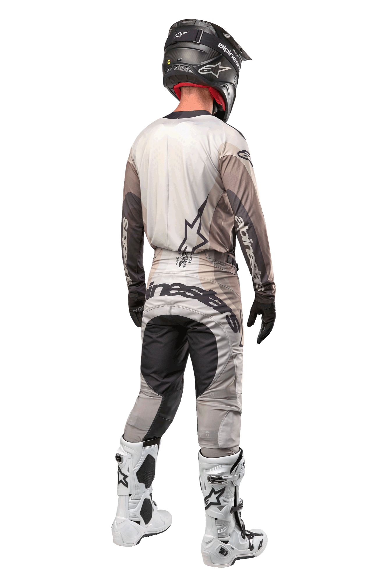 Motocross-Fahrer in der Rückansicht im 2024 Techstar Pneuma Trikot in Dark Sand Iron Dust Gray, passende Motocross-Hose mit markantem Branding, schwarzer Helm und weiße Rennstiefel, abgestimmte professionelle Offroad-Ausrüstung.