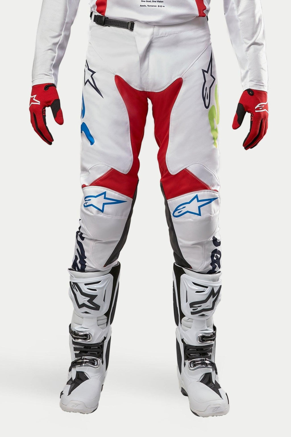 Alpinestars 2024 Racer Hana Hose, Motocross-Hose, Weiß mehrfarbig mit roten, blauen und limettengrünen Akzenten, getragen mit weißen und schwarzen Stiefeln und roten Handschuhen, mit Alpinestars-Logos auf den Knien und einem strapazierfähigen technischen Design für den Offroad-Rennsport