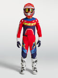 Alpinestars Supertech Jugend-Trikot Dyna 2027 und Gear Set, Motocross-Rennausrüstung für junge Fahrer, Feuerrot und Marineblau mit gelben Akzenten, getragen von einem Jugendfahrer.