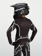 Alpinestars Fluid Apex V2 Jugend-Trikot, Motocross-Ausrüstung in Schwarz und Silber, Rückansicht mit ergonomischem Schnitt.