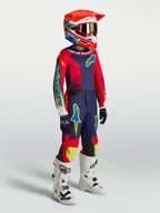 Alpinestars Jugend-Fluid Drag Gear Set 2027, Motocross-Rennbekleidung in Dunkelblau und Feuerrot mit weißen Stiefeln.