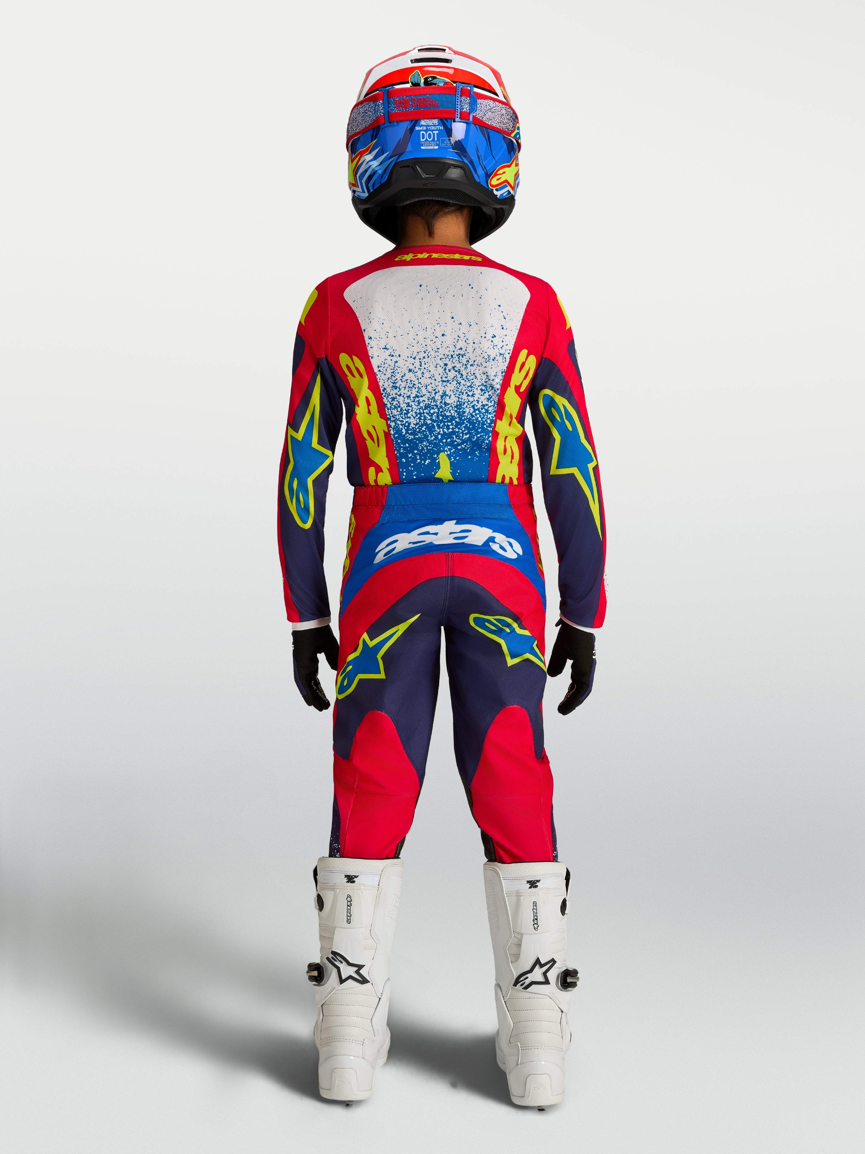 Alpinestars Fluid Jugend-Trikot Drag 2027 und Gear Set, Motocrosskombi in Marineblau und Feuerrot, Rückansicht auf Fahrer.
