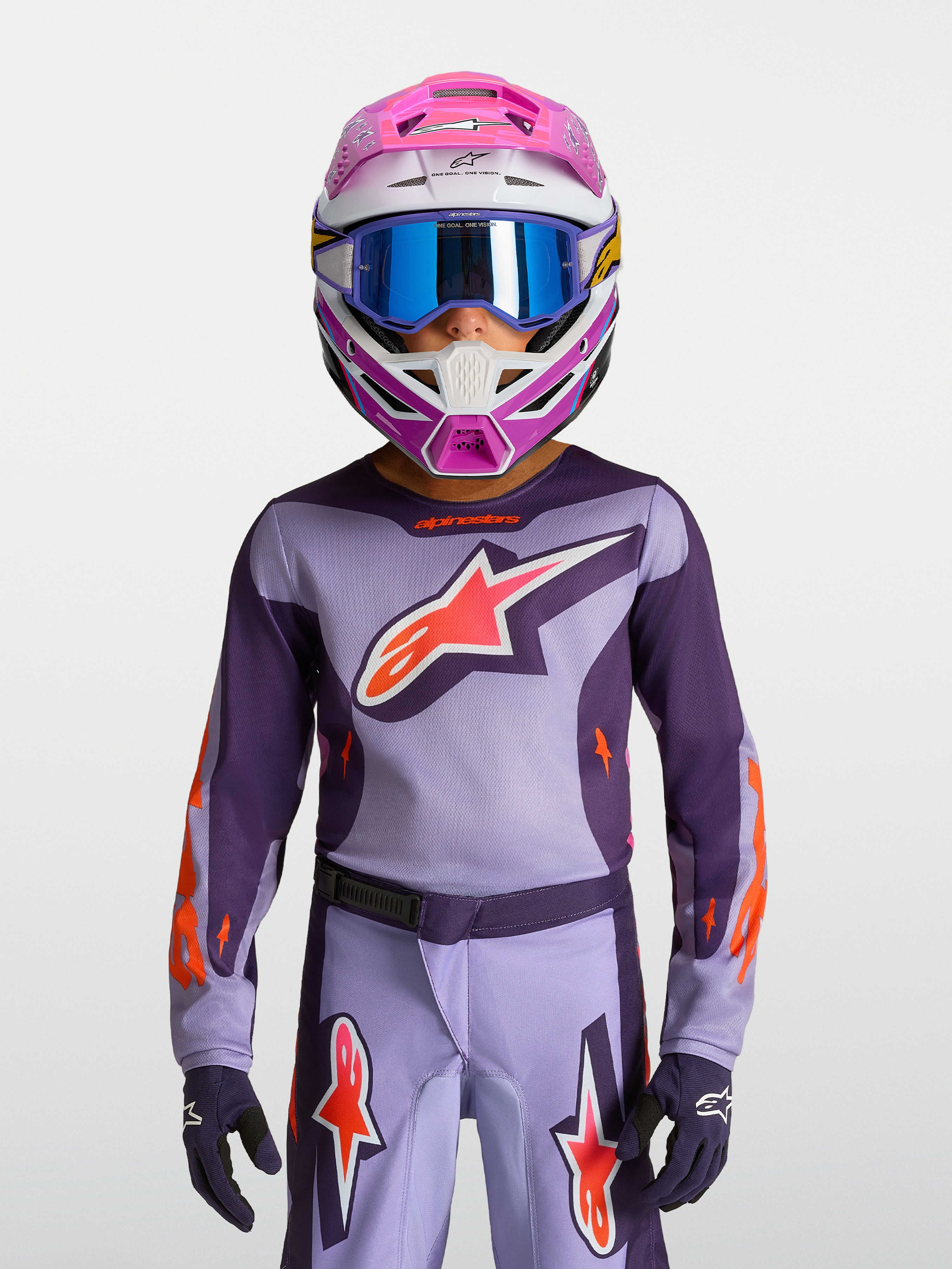 Alpinestars 2027 Youth Fluid Hunt Jersey, purple and pink fluo youth motocross gear, on-model with racing helmet and goggles.