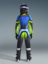 Jugend-Motocross-Fahrer von hinten in kompletter Rennausrüstung, blaues und neongelbes Supertech Nomur Jersey, passende Hose mit weißem Branding am Gesäß, schwarzer Helm mit lila Brille, schwarze Stiefel, abgestimmtes Outfit für Offroad-Rennen