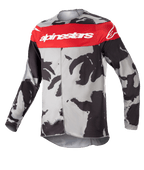 Alpinestars Youth 2023 Racer Tactical Jersey, Motocross Jersey, Cast Gray Camo and Mars Red, featuring a horizontal red chest band with white Alpinestars logo, gray and black camouflage pattern, lightweight moisture-wicking fabric for off-road riding