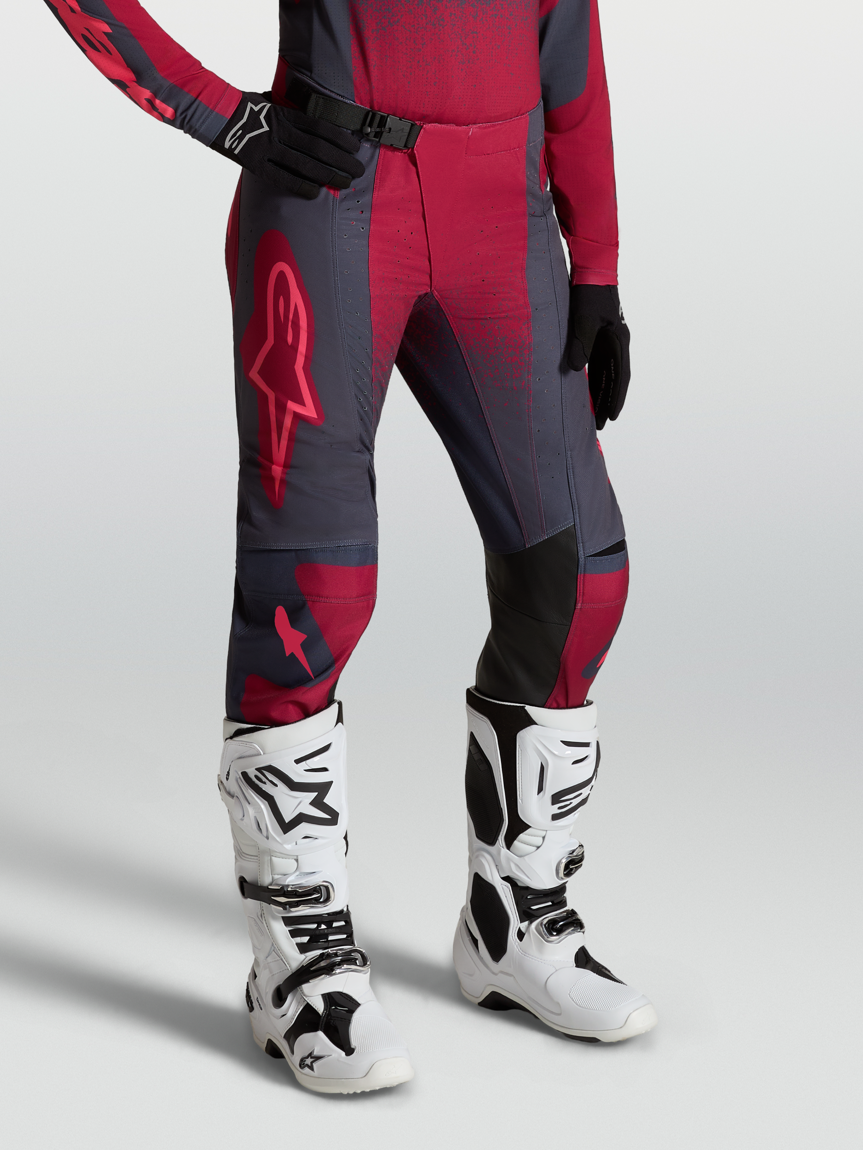 Alpinestars Stella Techstar Swan Damen-Motocross-Hose, Karminrot und Dunkelgrau, kombiniert mit weißen Tech 10 Stiefeln.