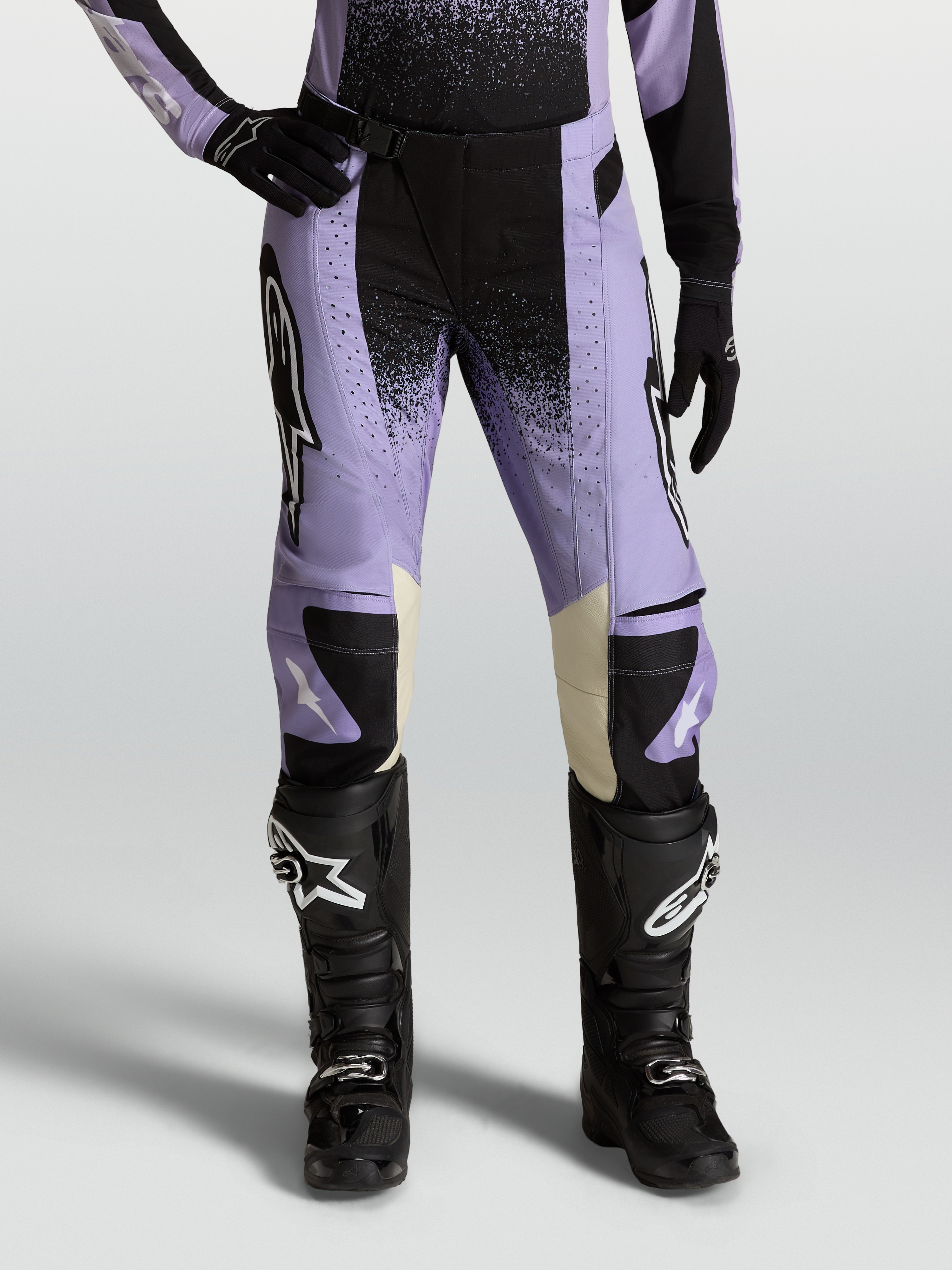 Stella Techstar Swan Pants, women's motocross racing pants in Light Violet and Black with cream leather accents, paired with black off-road boots.