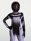 Alpinestars Stella Techstar Swan Trikot, Damen-Motocross-Jersey in Hellviolett und Schwarz, Race-Fit, getragen von einem Model mit Helm.