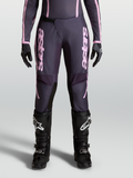 Alpinestars Stella Fluid Apex V2 Hose, Damen-Motocross-Hose in Grau und Pink, Modell an der Frontansicht mit Ratschenverschluss, 600D-Polygewebe, kombiniert mit schwarzen MX-Stiefeln und Handschuhen.