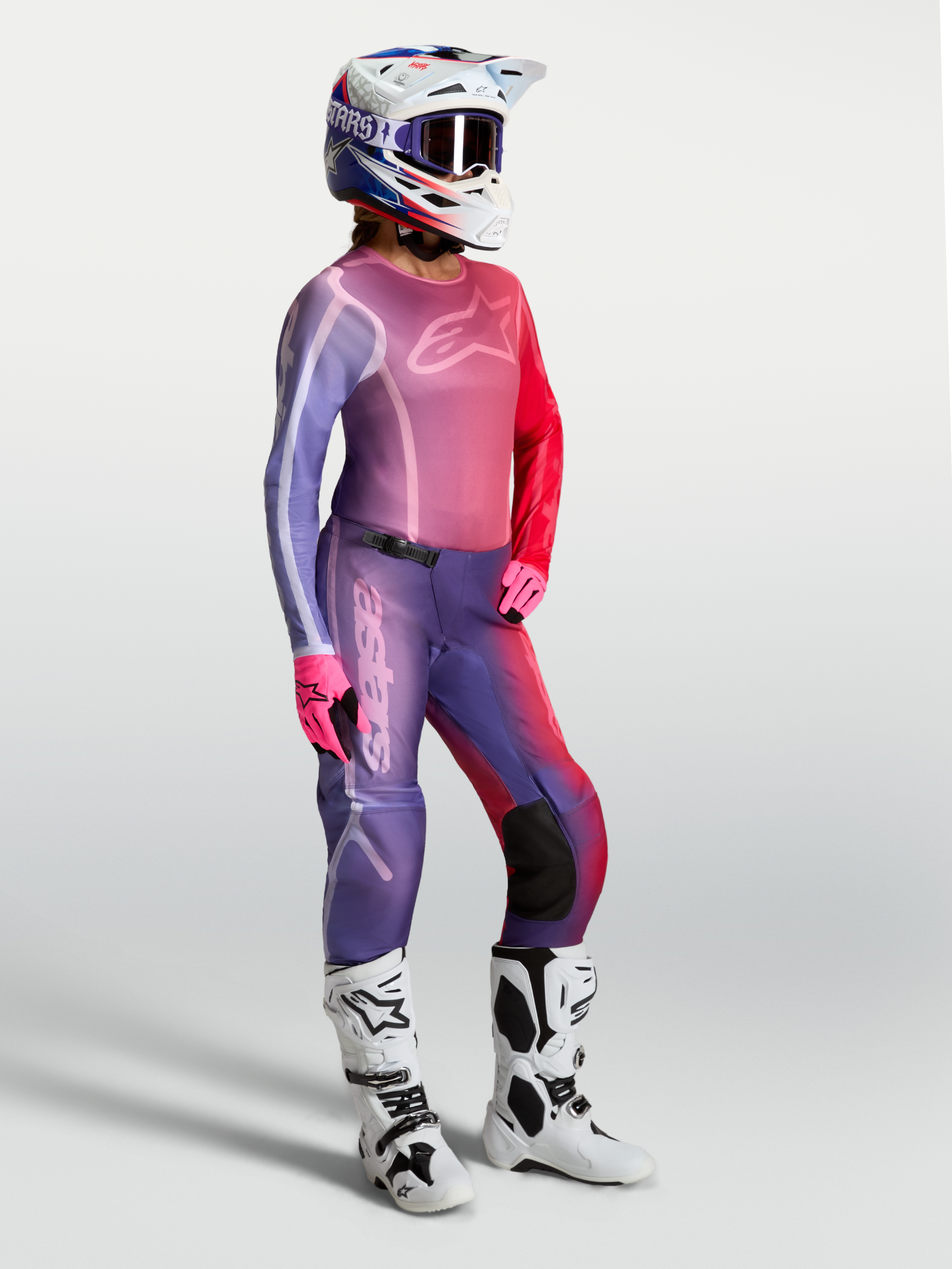 Alpinestars Stella Fluid Kepler Damen-Motocross-Trikot in Lila und Rot, mit passender Hose und weißen Stiefeln.