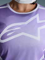 Alpinestars 2026 Stella Fluid Apex Trikot, Nahaufnahme der Brust, Lila mit weißen Grafiken, großes weißes Astars-Logo auf Mesh-Polygewebe-Konstruktion.