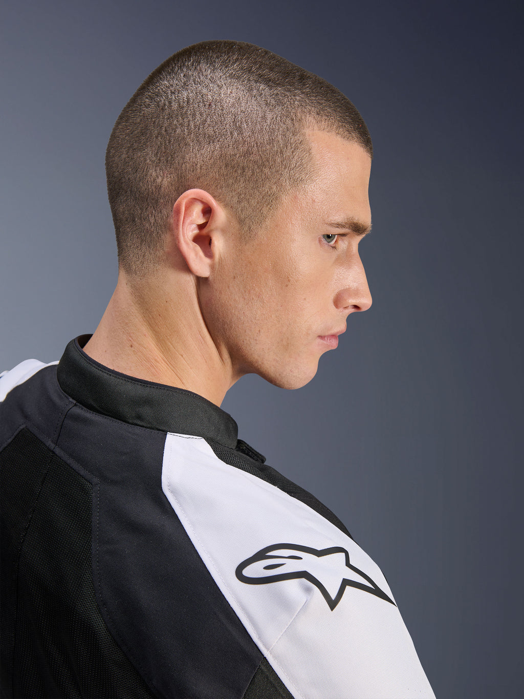 Alpinestars Viper Air V4 Jacke, Schwarz und Weiß, Seitenprofil eines männlichen Models, das die Jacke trägt, weißer Schultereinsatz mit schwarzem Alpinestars-Logo, Tech-Mesh-Konstruktion für Belüftung, sportliche Motorrad-Straßenausrüstung