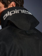 Alpinestars Chrome Superairflow Hoodie, Schwarz, Detailansicht der 3D-Mesh-Kapuze mit weißem Alpinestars-Branding auf der Oberseite, zeigt den rückseitigen Stabilisierungs-Druckknopf, belüftete Textil-Motorradausrüstung für extreme Hitze