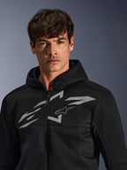 Alpinestars Chrome Superairflow Hoodie, schwarzer Motorrad-Hoodie, verfügt über eine 3D-Mesh-Konstruktion mit einem großen weißen Grafik-Logo auf der Brust, von einem Model getragen, urbane Sport-Fahrbekleidung mit modernem, belüftetem Design