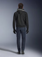 Alpinestars Chrome Superairflow Hoodie, schwarzer Motorrad-Hoodie mit weißem Branding auf der Kapuze, Rückansicht, getragen mit dunkelblauen Jeans, schwarzen Handschuhen und schwarz-weißen Stiefeln, urbane Sport-Fahrausrüstung