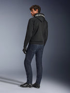 Alpinestars Chrome Superairflow Hoodie, Schwarz, Rückansicht an männlichem Modell, weißes Alpinestars-Branding auf der Kapuze, kombiniert mit dunklen Denim-Jeans und schwarzen Handschuhen, urbanes Motorrad-Design