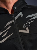 Alpinestars Chrome Superairflow Hoodie, Motorrad-Hoodie, Schwarz mit weißen und grauen Grafiken, Nahaufnahme der Brust mit technischer 3D-Mesh-Konstruktion, Frontreißverschluss und Druckknopfkragen, mit Alpinestars-Logo