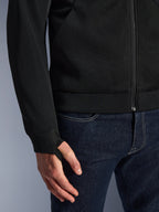 Alpinestars Chrome Superairflow Hoodie, Schwarz, Nahaufnahme des hochbeständigen technischen 3D-Mesh-Gewebes, mit geripptem Stretch-Jersey-Bündchen und elastischer Daumenschlaufe, getragen mit blauen Jeans