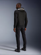 Alpinestars Chrome V2 Sport Hoodie, Schwarz, Rückansicht mit weißem Alpinestars-Branding auf der Kapuze, getragen mit schwarzer Hose und Motorradschuhen, lässige urbane Motorradbekleidung mit athletischer Silhouette