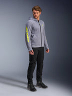 Alpinestars Chrome V2 Sport Hoodie, Grau meliert und Fluo-Gelb, getragen von einem männlichen Model mit schwarzer Hose und schwarzen Motorradschuhen, mit auffälligem gelbem Branding am Ärmel und auf der Brust, lässige urbane Motorradbekleidung