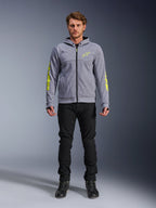Alpinestars Chrome V2 Sport Hoodie, Grau meliert mit neongelben Akzenten, urbane Motorradbekleidung, kombiniert mit schwarzer Hose und schwarzen Motorradschuhen, technisches Fleece mit auffälligem gelben Branding auf Ärmeln und Brust, lässiger Streetstyle zum Fahren