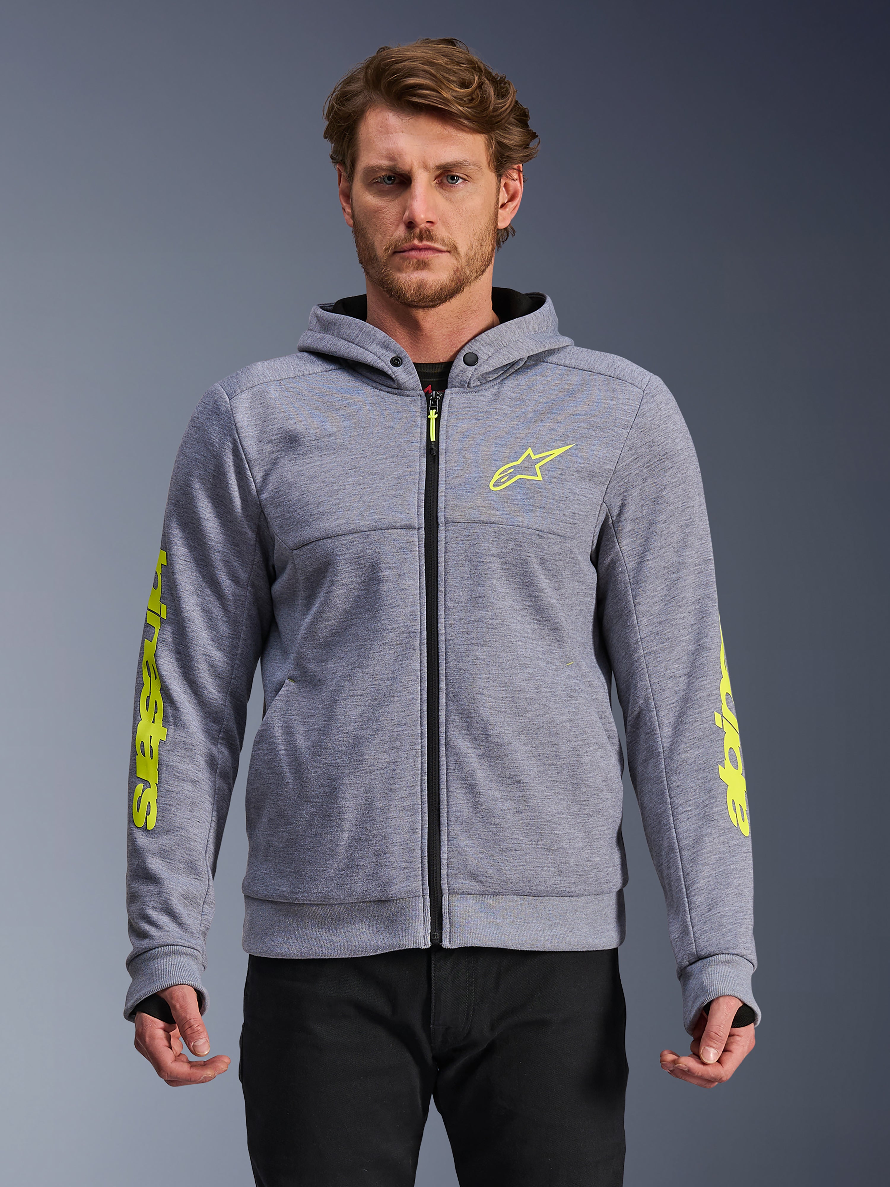 Alpinestars Chrome V2 Sport Hoodie, hellgrau meliert und neongelb, Motorrad-Kapuzenpullover mit Reißverschluss, gelbes Stern-Logo auf der Brust und gelber Schriftzug am Ärmel, Daumenschlaufen und schwarzer Reißverschluss, Tech-Fleece-Gewebe, lässige urbane Fahrausrüstung
