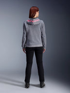 Alpinestars Stella Chrome V2 Sport Hoodie, Motorrad-Kapuzenjacke für Damen, Grau Meliert und Pink Fluo, Rückansicht mit pinkem Alpinestars-Logo auf der Kapuze, getragen mit schwarzer Motorradhose und Stiefeln, lässige Motorradbekleidung für Damen