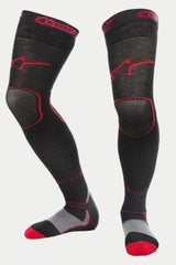 Alpinestars MX Long Tech Thick Socks, Motocross Riding Socks, Black and Red, featuring red Alpinestars logos on the thigh and cuff, gray heel and red toe accents, mid-thigh length with specialized mesh zones, technical base layer for off-road racing