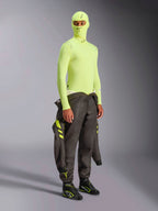 Alpinestars ZX Evo V3 Langarm-Oberteil, Yellow Fluo, Motorsport Base-Layer getragen mit passender Sturmhaube und dunklem Rennanzug um die Taille gebunden, hochsichtbare neongelbe feuerfeste Unterwäsche