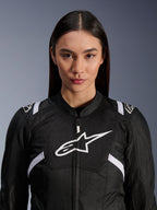 Weibliches Model trägt Alpinestars Stella T-SPS Air V2 Jacke, Motorradjacke für Damen, Schwarz und Weiß, mit atmungsaktiven Mesh-Einsätzen und weißem Alpinestars-Logo auf der Brust, sportliches Design für Straßenfahrten