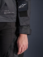Alpinestars Molly Air Jacke, Detailansicht von schwarzem Ripstop-Textil, weißes Astar-Logo auf Ärmeltasche mit Klett-Patch, verstellbarer Ärmelbund und aufgedruckter Markenschriftzug an der Seite, urbane Motorradbekleidung für Damen