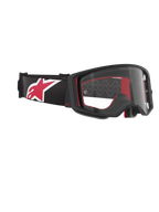 Alpinestars Supertech Corp Goggles, Motocross-Brille, Schwarz, Rot und Klar, schräge Seitenansicht mit klarem Glas und schwarzem Rahmen, rote Innenpolsterung, schwarzes Brillenband mit großem rot-weißem Alpinestars-Logo, professioneller Offroad-Augenschutz
