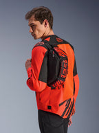 Alpinestars MM93 Hüfttasche, Schwarz mit Red Fluo und Bright Red, von einem Model über dem Rücken über einer rot-schwarzen Motorradjacke getragen, mit markantem MM93-Branding und Marc-Marquez-Grafiken
