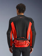 Alpinestars MM93 Hüfttasche, Rot und Schwarz, getragen über einer schwarz-roten Motorradjacke, mit Marc Marquez 93 Branding, verstellbarem Gurt und Reißverschlussfächern, funktionales, vom Rennsport inspiriertes Accessoire