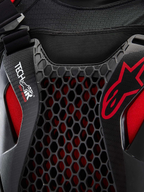 Alpinestars Tech-Air® Off-Road Airbag-System, Nahaufnahme des Offroad-Motorrad-Airbagsystems in Schwarz und Rot, mit Nucleon CELL Waben-Brustschutz, Tech-Air-Branding und atmungsaktivem Stretch-Mesh-Chassis